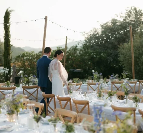 Image of married couple walking around tables looking at decorations at wedding venue Clos du Tuilier