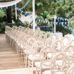 white ceremony chairs line the aisle on wooden deck at ibiza wedding venue kazamor ibiza