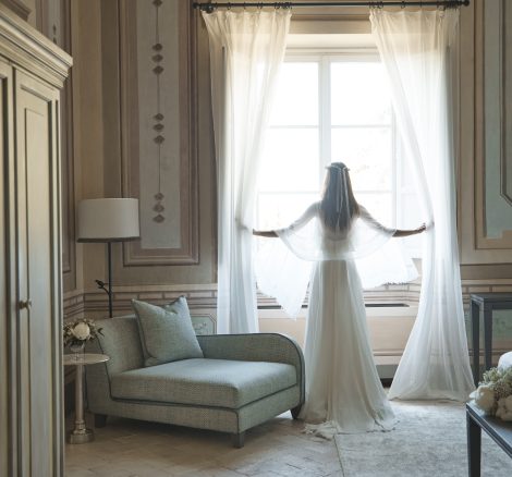 Bride in Heritage Suite at Window at luxury wedding venue in Tuscany COMO Castello Del Nero