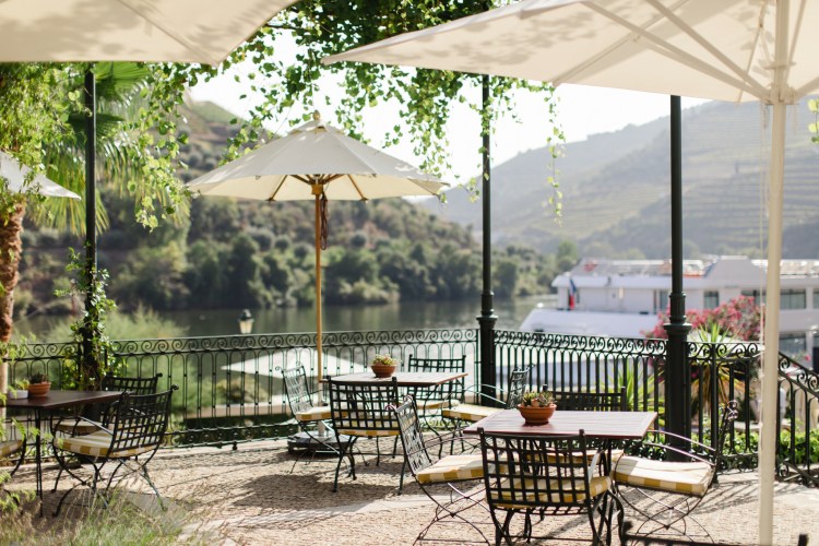 wedding venue the vintage house hotel terrace area with metal chairs and umbrellas overlooking Douro river