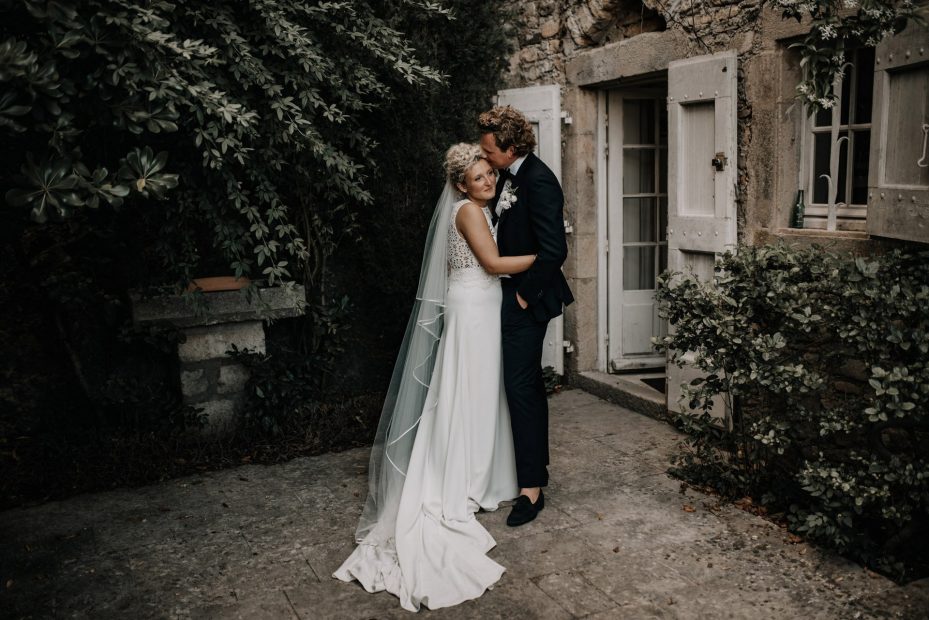 bride and groom stood outside rustic wedding venue domaine du rey in provence