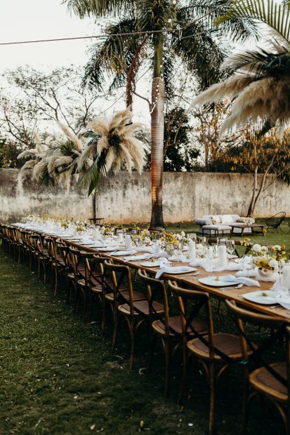 rustic table decor amidst palm trees at wedding venue in Mexico Hacienda Sac Chich