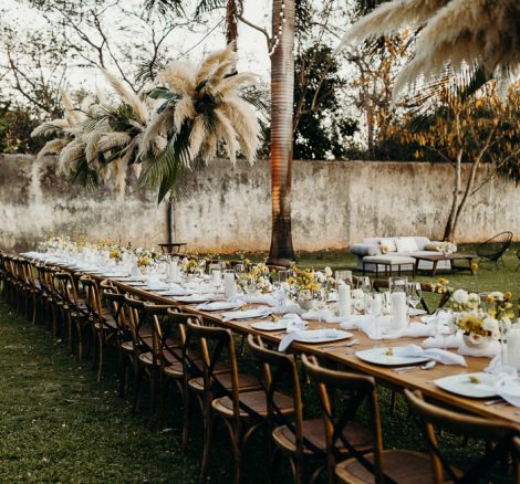 rustic table decor amidst palm trees at wedding venue in Mexico Hacienda Sac Chich