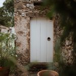 quaint french wooden door wooden benches and pampas for wedding ceremony outside at wedding venue in france provence