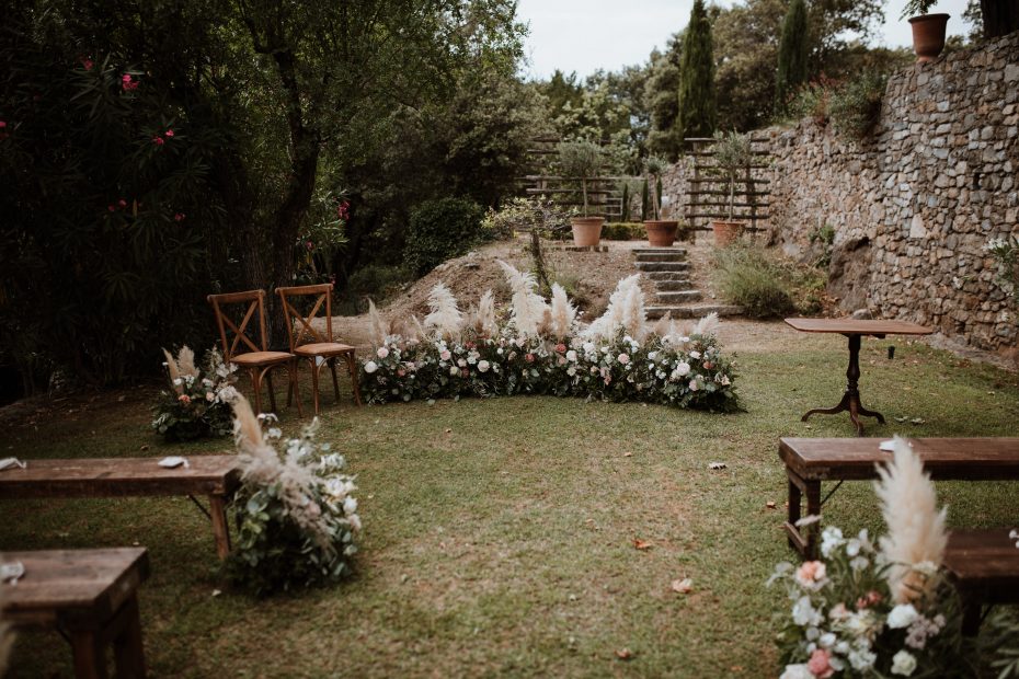 wooden benches and pampas for wedding ceremony outside at wedding venue in france provence