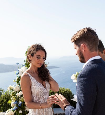 bride accepts ring during ceremony at wedding venue in Santorini venetsanos winery