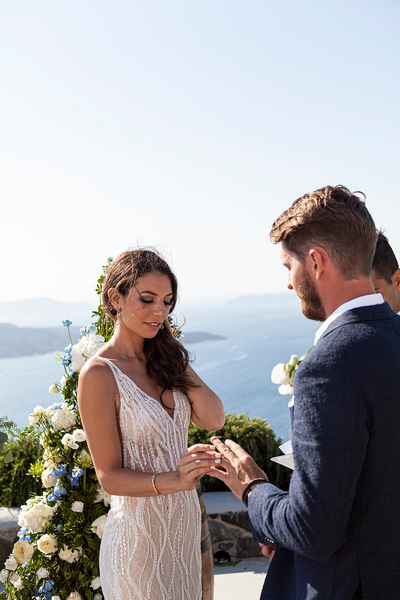 bride accepts ring during ceremony at wedding venue in Santorini venetsanos winery