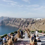 bride and groom exchange vows on cliff edge with sea view at wedding venue in Santorini venetsanos winery