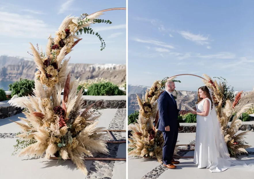 bride and groom stand in front of floral pampas ceremony arch at wedding venue in Santorini venetsanos winery