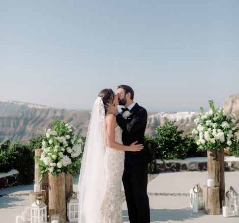 bride and groom kiss and say I do at wedding venue in Santorini venetsanos winery