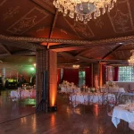 wedding dinner inside the grand hall at chateau wedding venue in france chateau de vallery