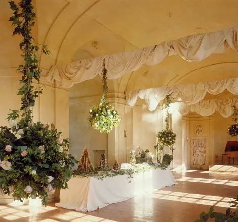 floral display hanging from ceiling of grand hall at chateau wedding venue in france chateau de vallery