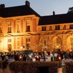 wedding guests partying outside in front of chateau wedding venue in france chateau de vallery