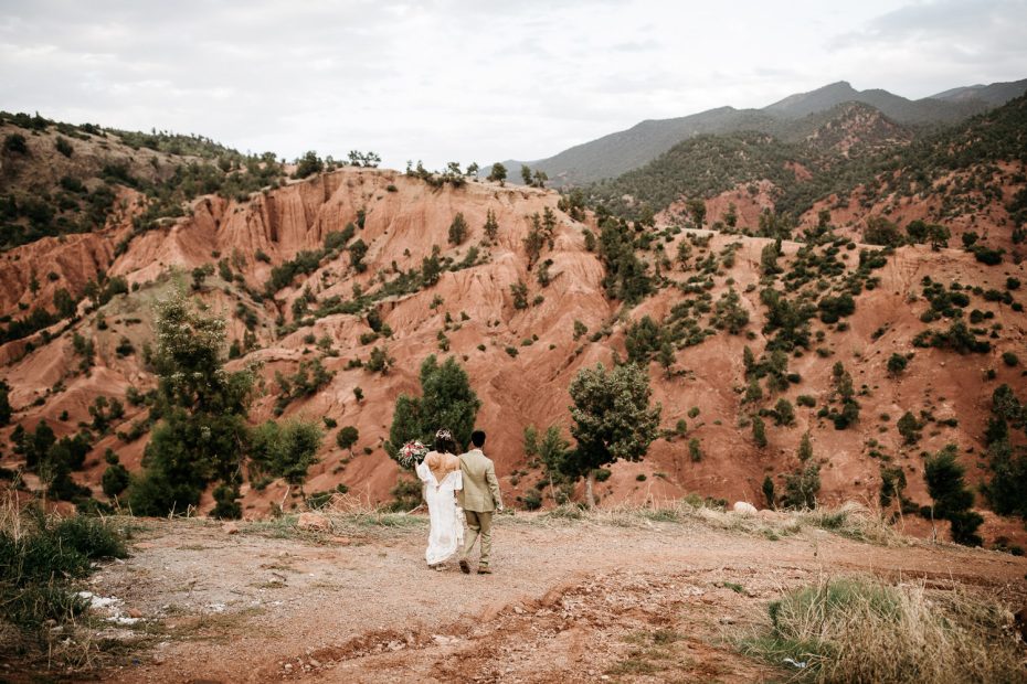 bride and groom walking through the atlas mountains at unique wedding venue in morocco kasbah bab ourika