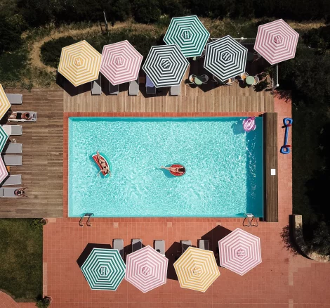 view above the pool and striped umbrellas at wedding venue in tuscany villa lena