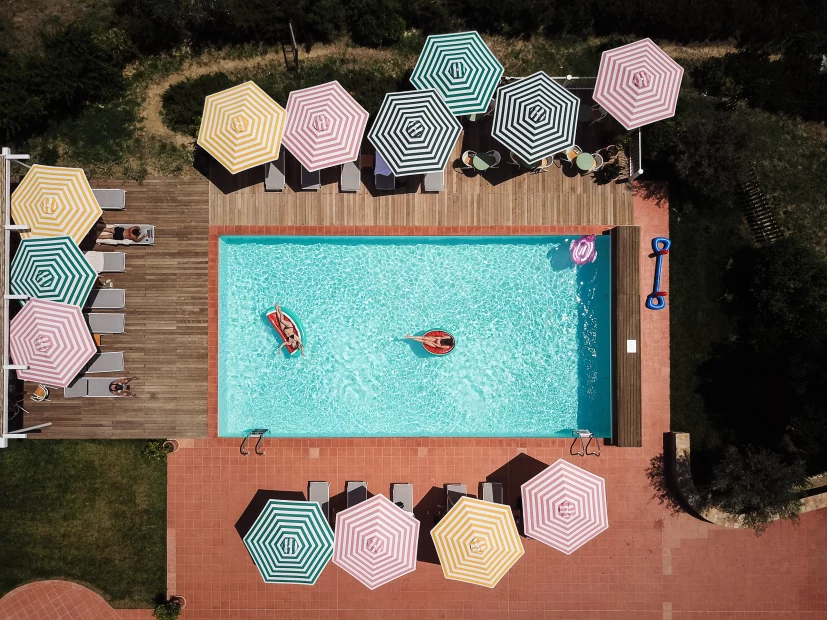 view above the pool and striped umbrellas at wedding venue in tuscany villa lena