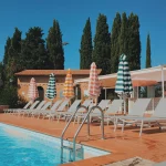 loungers and striped umbrellas at wedding venue in tuscany villa lena
