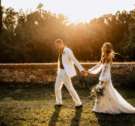 bride and groom walking hand in hand at sundown at wedding venue in tuscany villa lena