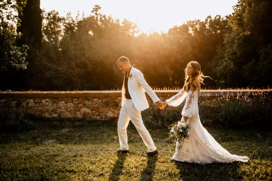 bride and groom walking hand in hand at sundown at wedding venue in tuscany villa lena