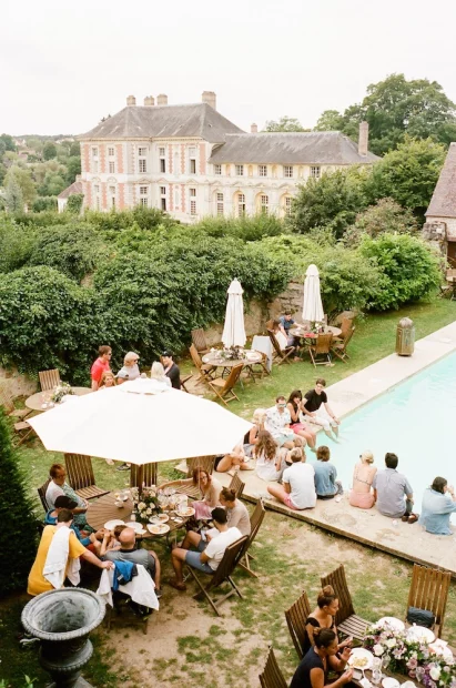 wedding guests lounging by the pool at chateau wedding venue in france chateau de vallery