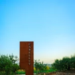 rusted sign at the entrance to the best vineyard wedding venue in Barcelona Spain Masia Cabellut