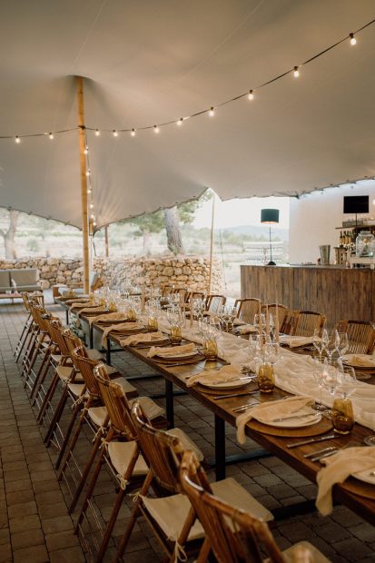 A long wooden wedding table under a marquee at Vineyard Wedding Venue Barcelona Masia Cabellut