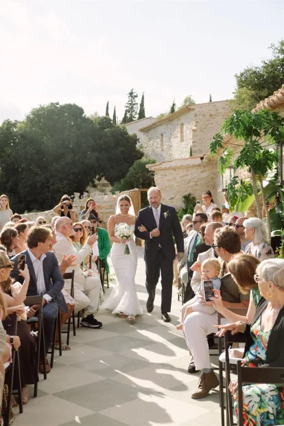 Image of bride walking down aisle with father at wedding venue Alcazar del Garraf
