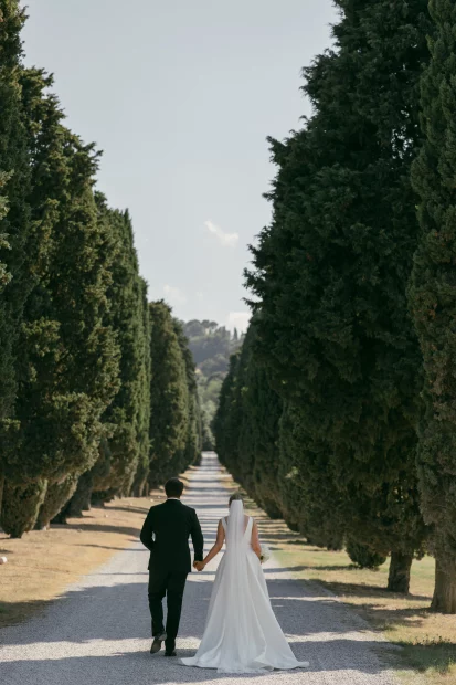 Couple walking down driveway entrance at wedding venue Relais Roncolo 1888, Italy