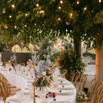 Table set up with fairy lights in trees at wedding venue Mas Palou