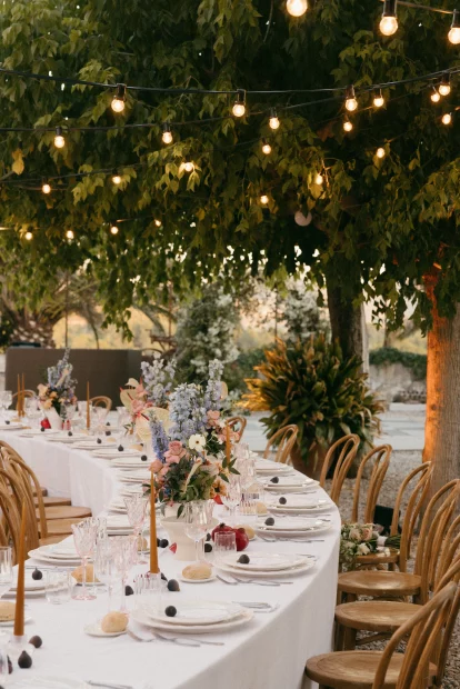 Table set up with fairy lights in trees at wedding venue Mas Palou