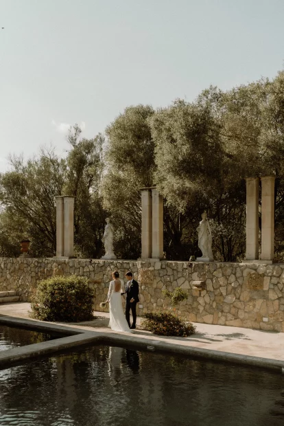 Married couple walking around the pool at wedding venue Finca Son Collell