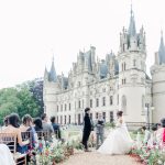 Image of couple at the end of aisle in front of wedding venue Chateau Challain