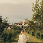 Image of bride running towards wedding venue Villa Gallici Deciani, Italy