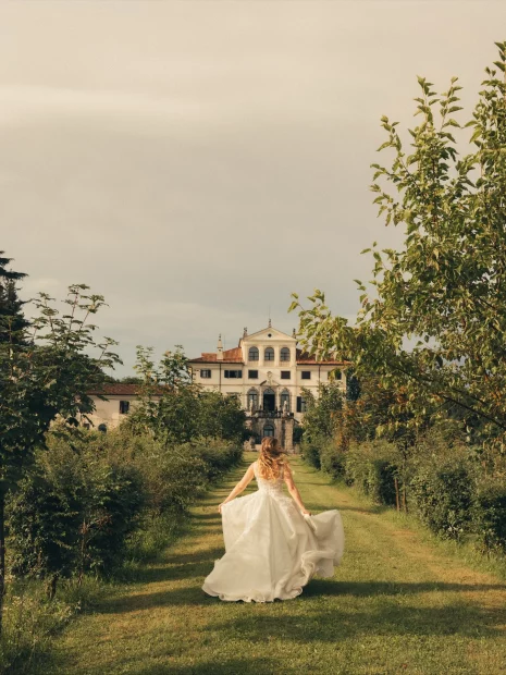 Image of bride running towards wedding venue Villa Gallici Deciani, Italy