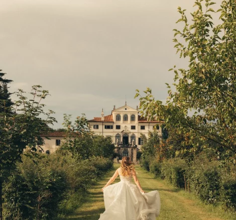 Image of bride running towards wedding venue Villa Gallici Deciani, Italy