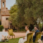 Image of couple sat at the front of the aisle at wedding venue Hotel Castell d´Emporda 