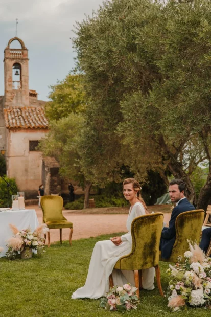 Image of couple sat at the front of the aisle at wedding venue Hotel Castell d´Emporda 