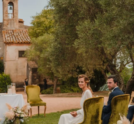 Image of couple sat at the front of the aisle at wedding venue Hotel Castell d´Emporda 