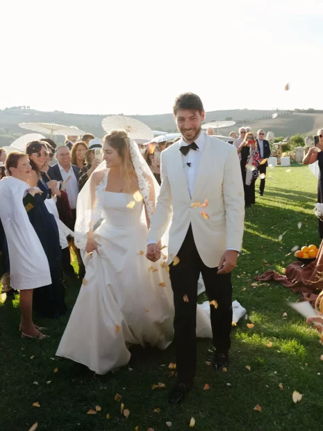 Couple walking down aisle with confetti at wedding venue Vitaleta, Italy