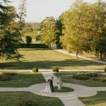 Image of married couple waling through gardens at wedding venue Château de Garde, France