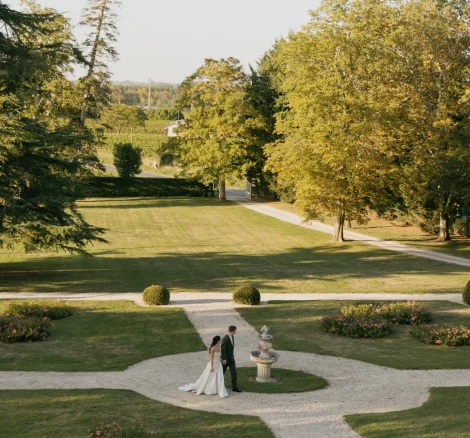 Image of married couple waling through gardens at wedding venue Château de Garde, France