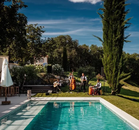 Image of a band playing by the pool at wedding venue Terra Rosa, France