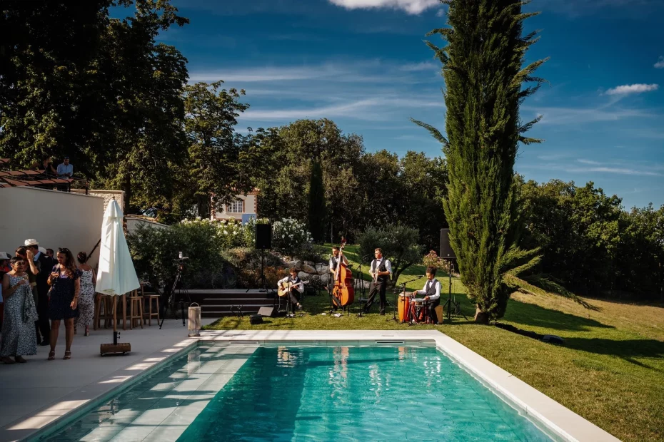 Image of a band playing by the pool at wedding venue Terra Rosa, France