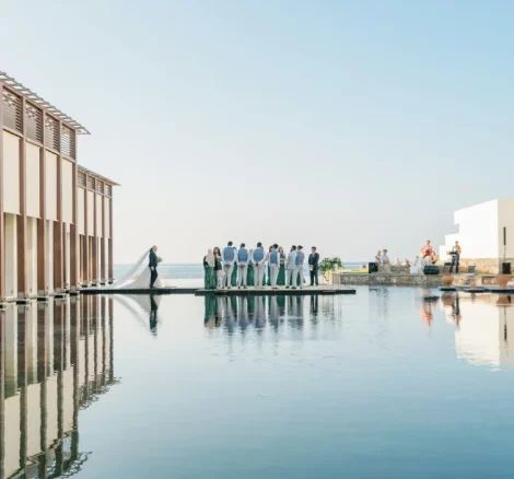 Image of wedding guests & couple on floating deck at wedding venue in Crete, Greece Amirandes