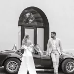 Image of married couple standing by car outside wedding venue El Serral Hotel, Spain