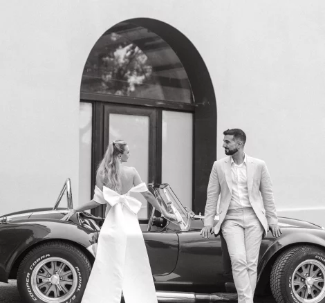 Image of married couple standing by car outside wedding venue El Serral Hotel, Spain