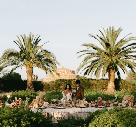 Image of couple looking at dining table with palm trees around them at wedding venue Vestige Son Vell