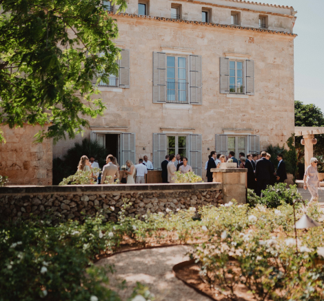 Image of wedding guests standing outside in front of wedding venue Vestige Son Vell